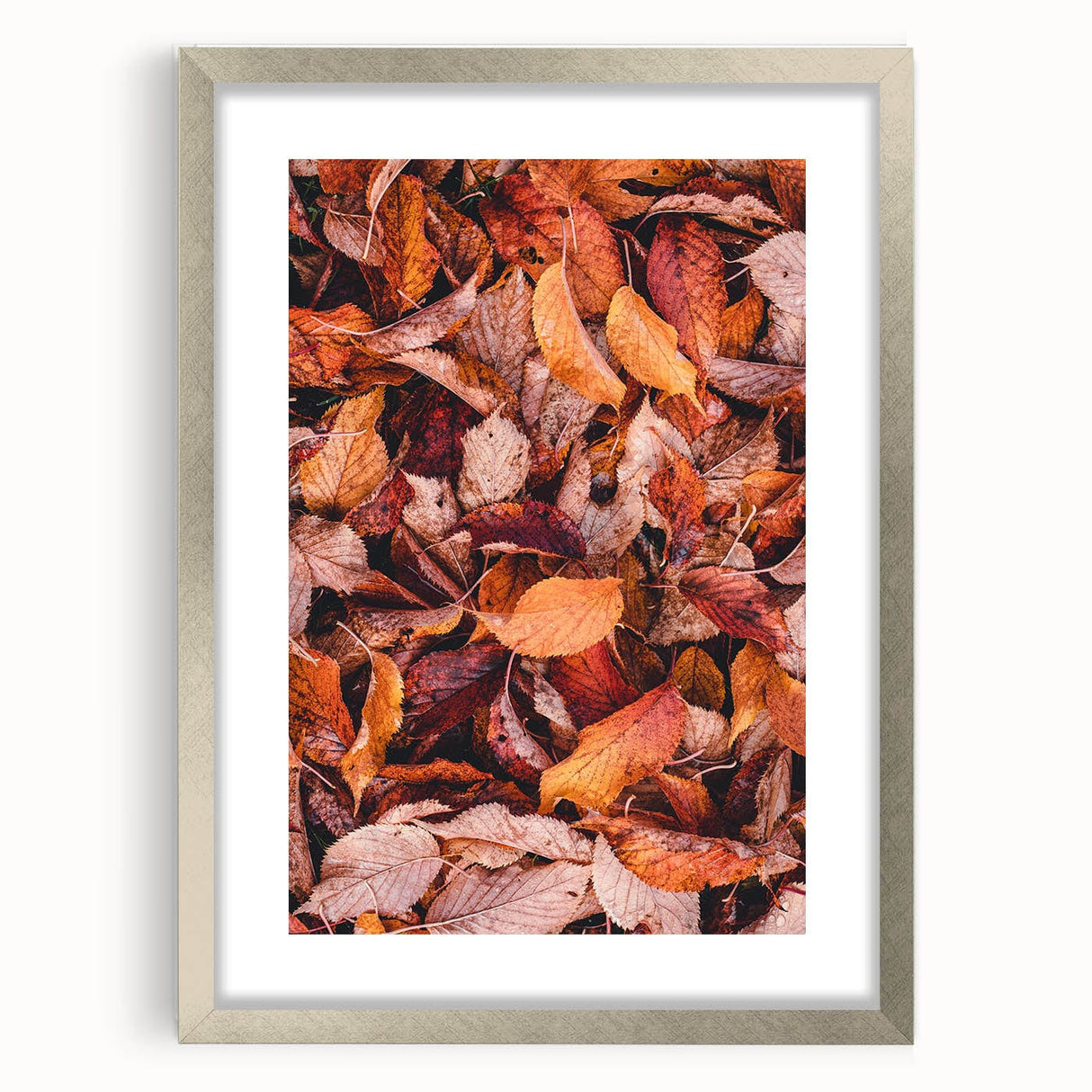Textured abstract art print in warm autumnal hues on a silver-framed canvas, suited for bedroom decor.