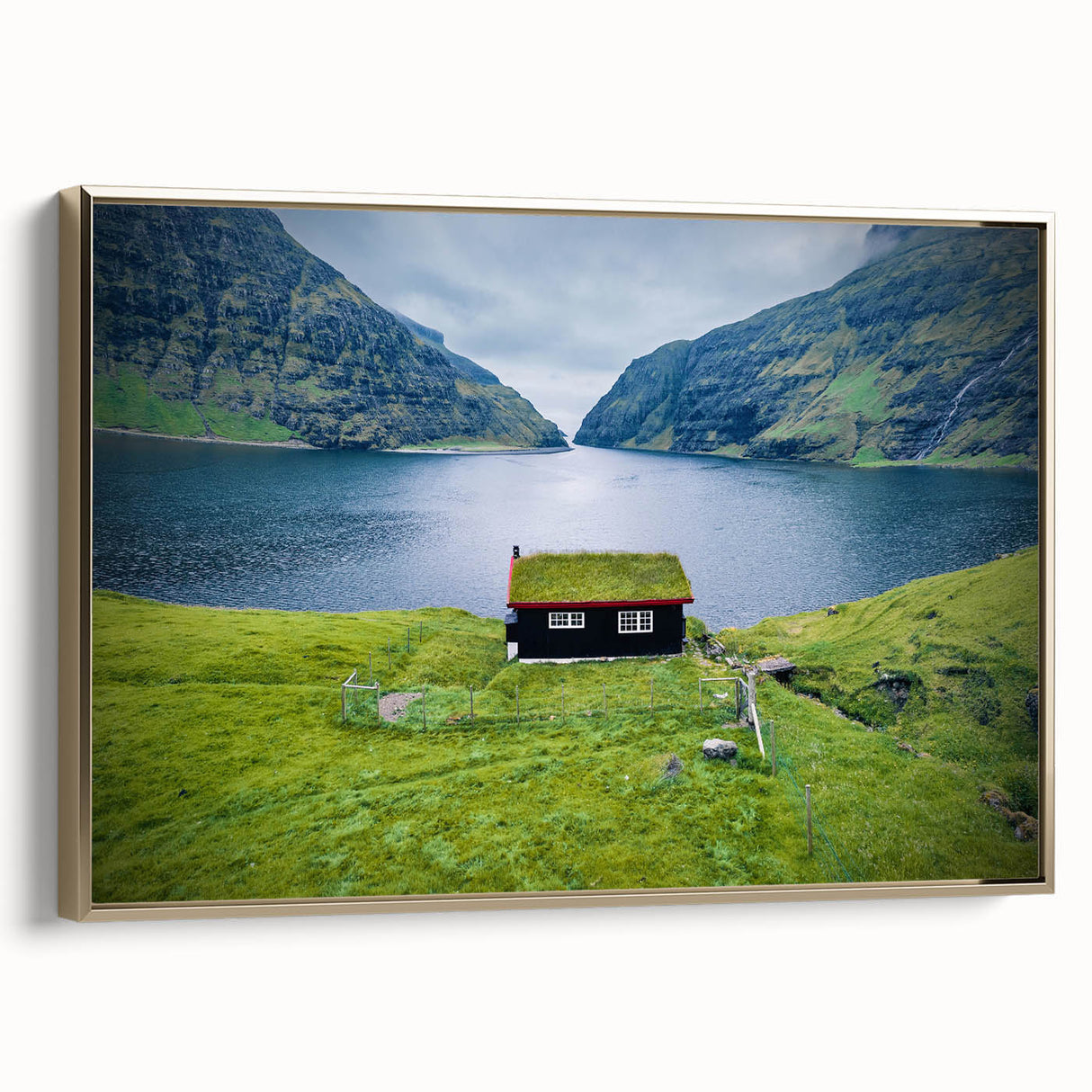 Framed canvas featuring a vintage-style landscape painting of a European scenery in muted gold and black tones.