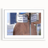 Abstract art print of Tel Aviv skyline in muted gray and blue tones on a white-framed mat, ideal for dining room decor.