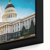 A close-up of textured black wall art depicting Sacramento scenery on a framed canvas, highlighted with colorful accents.