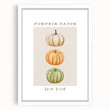 Abstract art print depicting fall foliage in orange and red tones on a white framed canvas, suited for dining room decor.