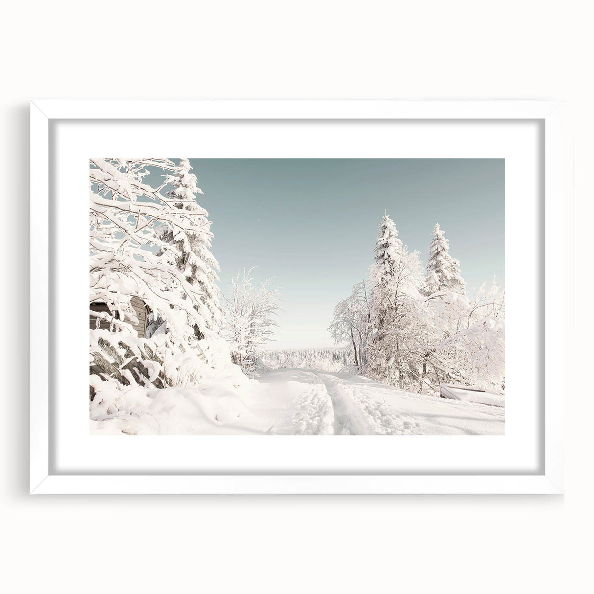 Abstract art print depicting winter-themed shapes in muted blue and white tones on a framed canvas.