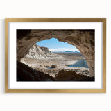 Framed gold landscape artwork depicting a serene cave scene, elegantly matted, showcasing intricate details and vibrant colors, perfect for modern home decor.
