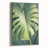 Framed canvas wall art depicting vibrant flowers and botanical leaves with a silver frame, showcasing a modern design ideal for home decor.