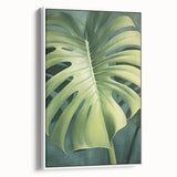 Framed canvas wall art showcasing a vibrant floral design with green leaves, set against a white background, ideal for home decor enhancement.