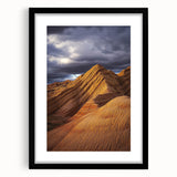 Framed landscape artwork depicting a serene desert scene, featuring warm tones of orange and brown, with a sleek black mat and frame, perfect for home decor.