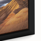 Close-up of a framed canvas artwork depicting a vibrant desert landscape, showcasing warm hues of orange and brown with intricate details of cacti and sand dunes. Perfect for home decor, this piece brings a touch of nature's beauty indoors.