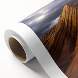 Desert landscape rolled canvas print showcasing vibrant hues of orange, red, and yellow depicting a sunset over dunes, ideal for home decor accent.