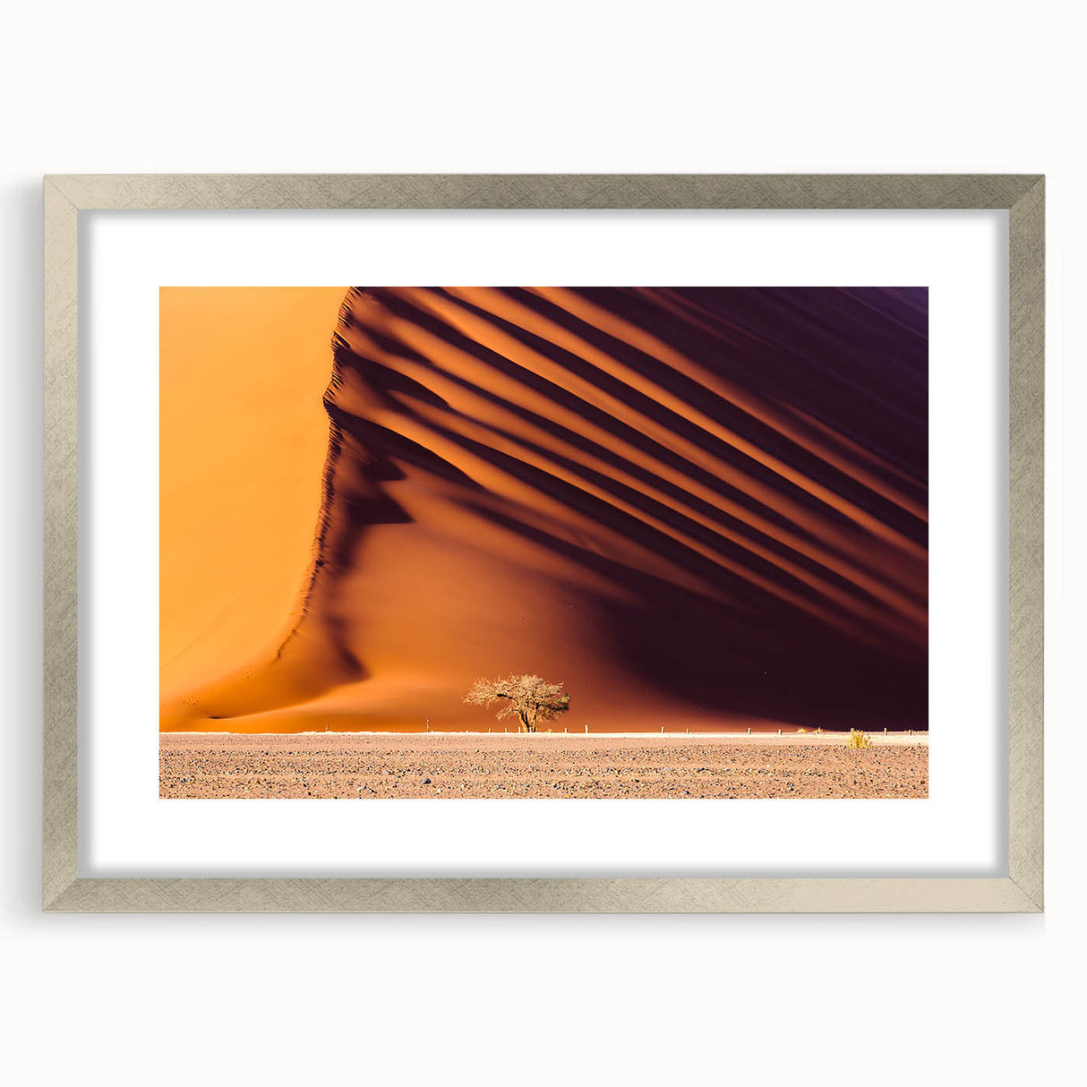 Abstract art print of an African scenery in muted earth tones on a framed silver mat, ideal for dining room decor.