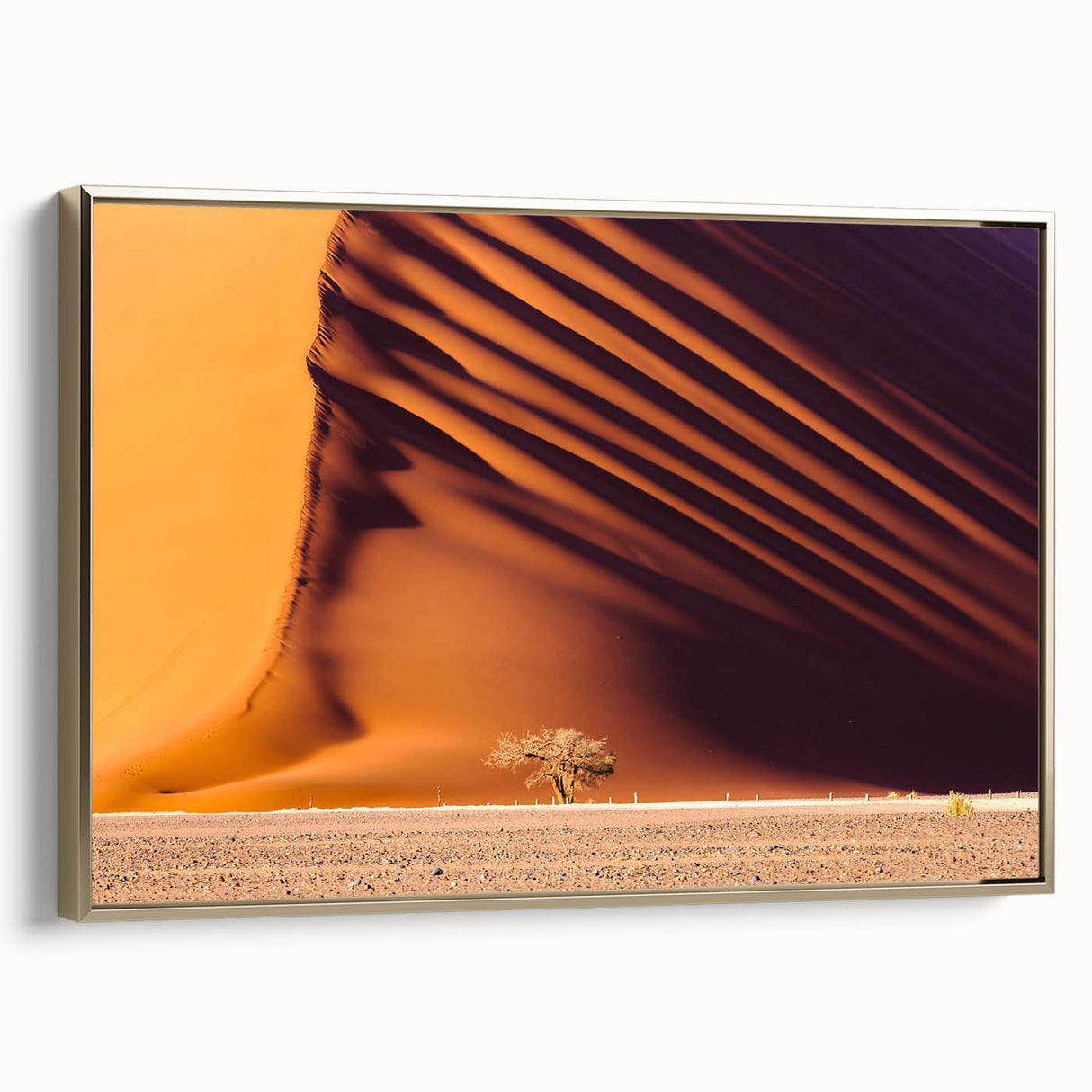 Framed canvas of a Namibian landscape featuring golden hues and black silhouettes, suitable for a living room.