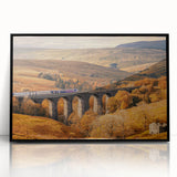 Large abstract wall art depicting a serene Cumbrian landscape in muted green and blue tones, framed in black acrylic.