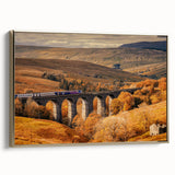 Framed canvas depicting a vintage-style landscape painting of the Cumbria countryside in muted earth tones.