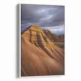 Framed canvas artwork depicting a serene desert landscape featuring soft beige and warm orange hues, showcased from a white side view to highlight its elegant presentation.