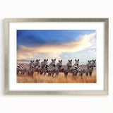 Textured art print of abstract African scenery in muted earth tones, framed in silver, ideal for bedroom decor.
