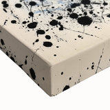 Close-up of a vibrant abstract splatter design on stretched canvas, showcasing dynamic colors and textures that enhance modern decor aesthetics, perfect for artistic spaces.