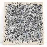 Abstract splatter art canvas leaning against a wall, showcasing vibrant colors like blue, orange, and yellow, perfect for modern home decor or art enthusiasts.