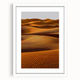 Framed landscape artwork depicting serene sand dunes under a blue sky, featuring a white mat and sleek black frame, perfect for home decor or office aesthetics.