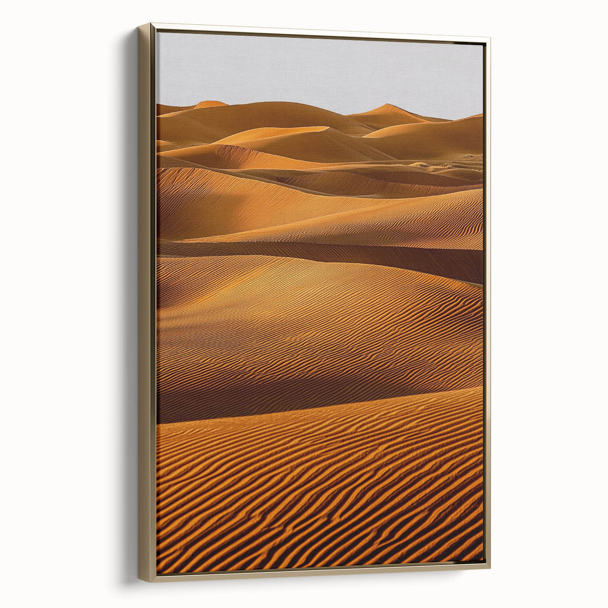 Framed canvas artwork showcasing a serene desert landscape with golden sand dunes, elegantly displayed from a side view to highlight its luxurious finish. Perfect for home decor.