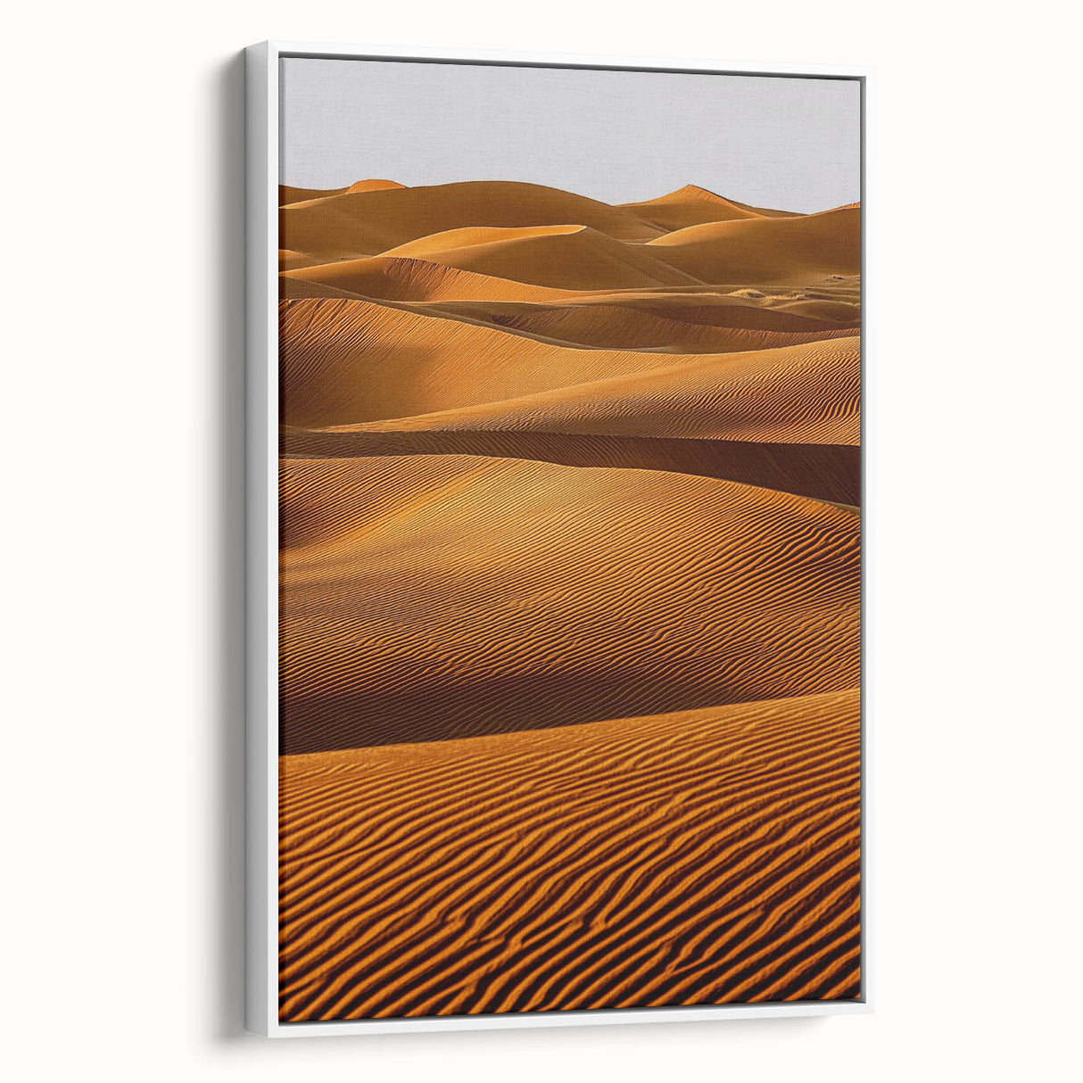 Framed canvas artwork showcasing a serene landscape of sand dunes, featuring warm beige and soft brown tones, displayed in a sleek white frame, ideal for home décor.