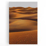 Stretched canvas artwork depicting serene sand dunes at sunset, showcasing warm orange and soft beige tones, ideal for modern home decor and relaxation spaces.