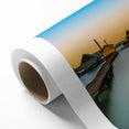 Art deco poster of a European cityscape in muted pastel hues on rolled canvas.