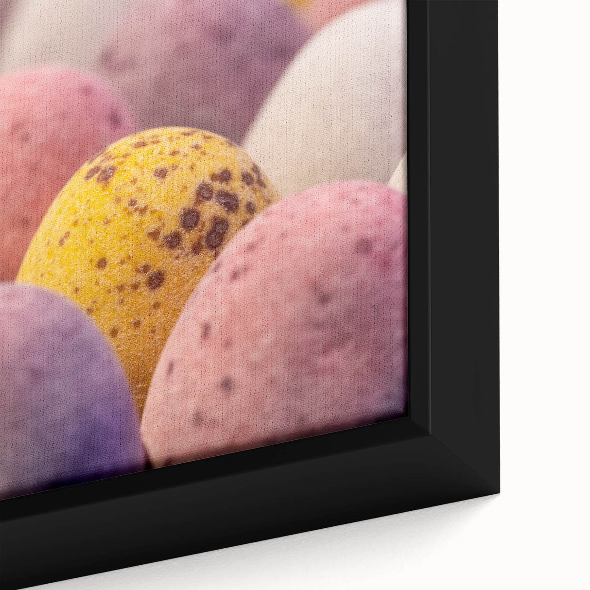 Close-up of a framed canvas featuring black textured art with colorful abstract spring motifs, ideal for living room decor.