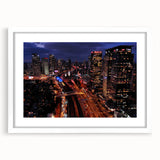 Abstract art print of Tel Aviv skyline in muted gray and blue tones on a framed white mat, suitable for dining room decor.