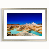 Textured abstract art print depicting a Bolivian landscape in earth tones, framed in silver, suitable for bedroom decor.