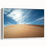 Framed canvas artwork depicting a serene desert landscape with warm tones of orange and beige, showcasing soft dunes and a clear blue sky, ideal for modern home decor.