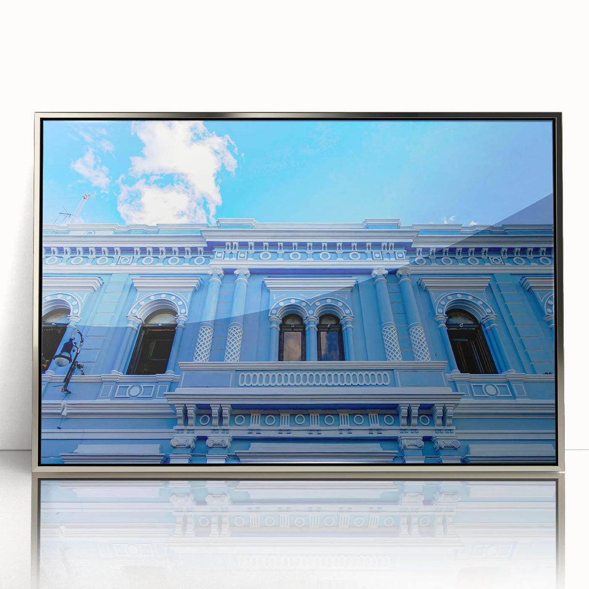 Mid-century modernist art of a Yucatan scenery in a silver-framed acrylic, featuring muted earth tones.