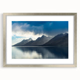 Textured art depicting the Grand Tetons, in muted earth tones on a framed silver mat, suitable for bedroom decor.