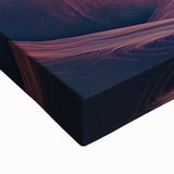 Close-up view of a vibrant stretched canvas depicting a serene landscape of colorful caves, showcasing intricate details and textures, ideal for home decor.