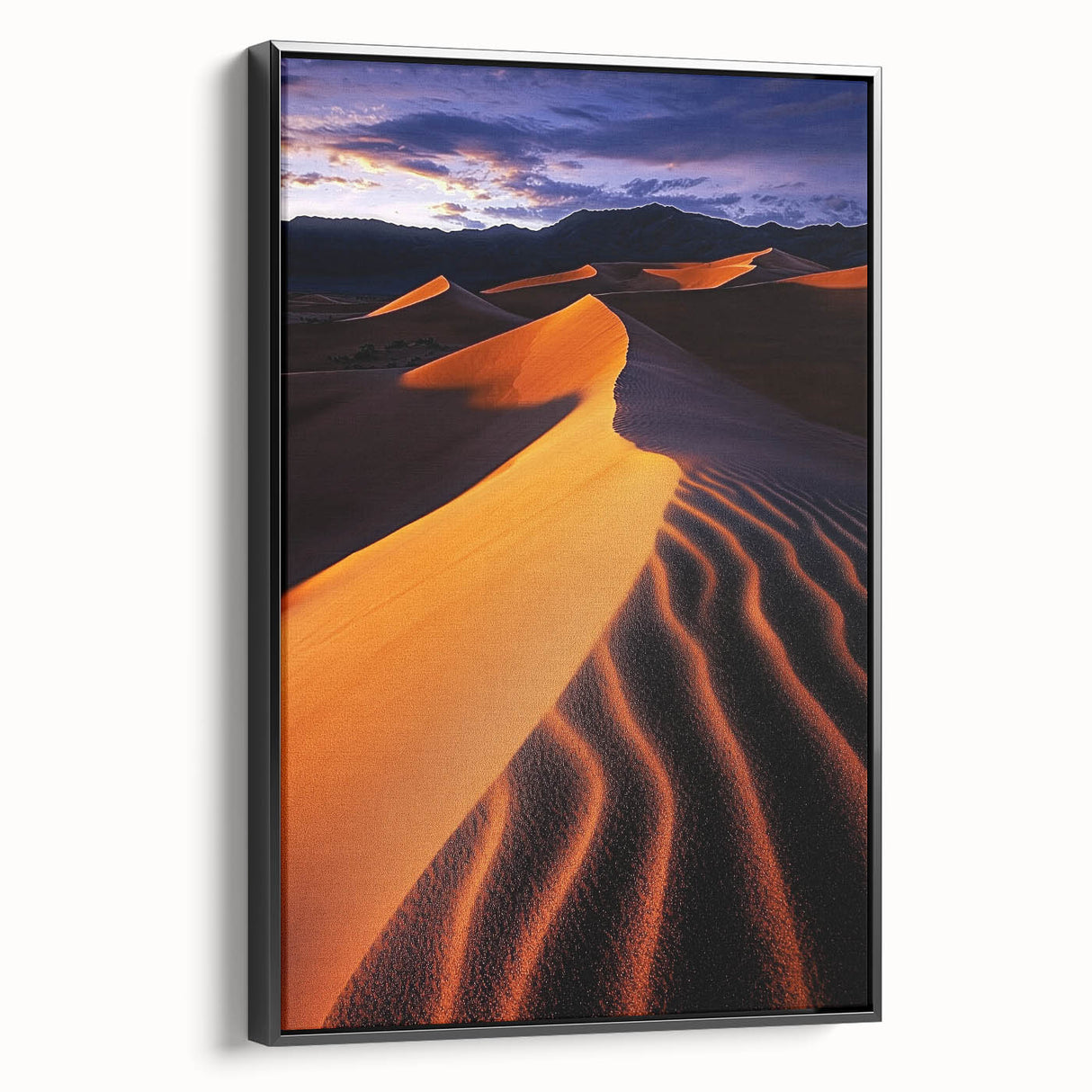 Framed canvas artwork depicting a serene landscape of rolling dunes, with a black frame and side view showcasing its textured surface, perfect for home decor.