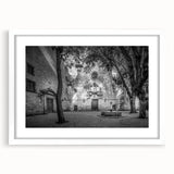 Textured abstract art print depicting a bustling Barcelona street scene in muted earth tones, framed in white.