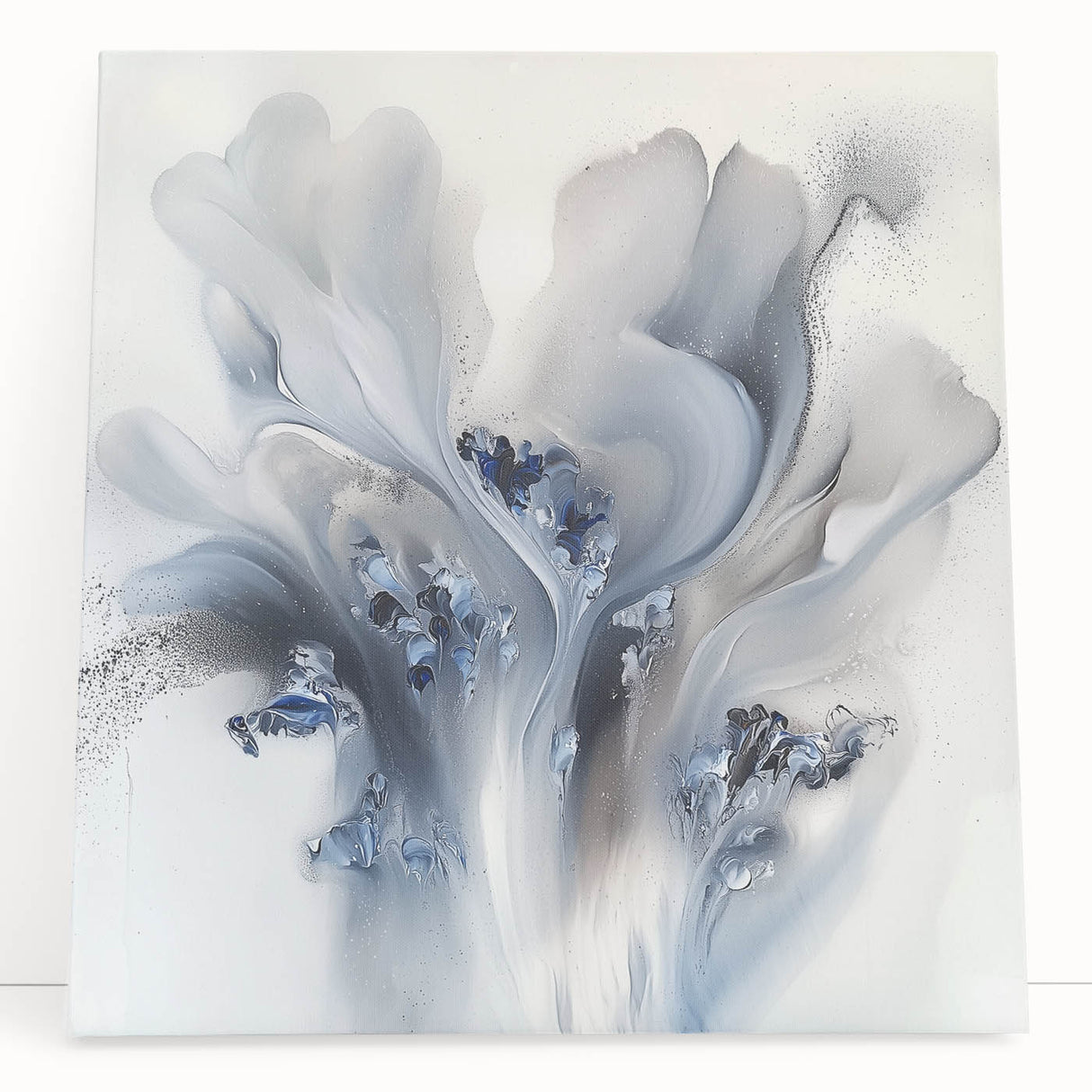Abstract floral artwork on stretched canvas featuring vibrant colors of pink, green, and blue, leaning against a neutral wall, perfect for modern home decor.