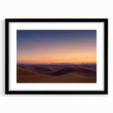 Desert landscape framed art print with a black mat, showcasing vibrant orange and yellow hues of a sunset over sand dunes, ideal for modern home decor.