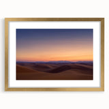Framed desert landscape wall art featuring a gold mat, showcasing vibrant hues of orange and blue, perfect for enhancing modern home decor.