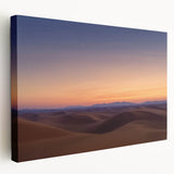 Stretched canvas artwork depicting a vibrant desert landscape in warm tones, showcasing rolling sand dunes under a bright blue sky, ideal for home decor.