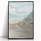 Framed acrylic artwork showcasing a serene desert landscape with golden sand dunes and a clear blue sky, presented in a sleek black frame, perfect for modern decor.