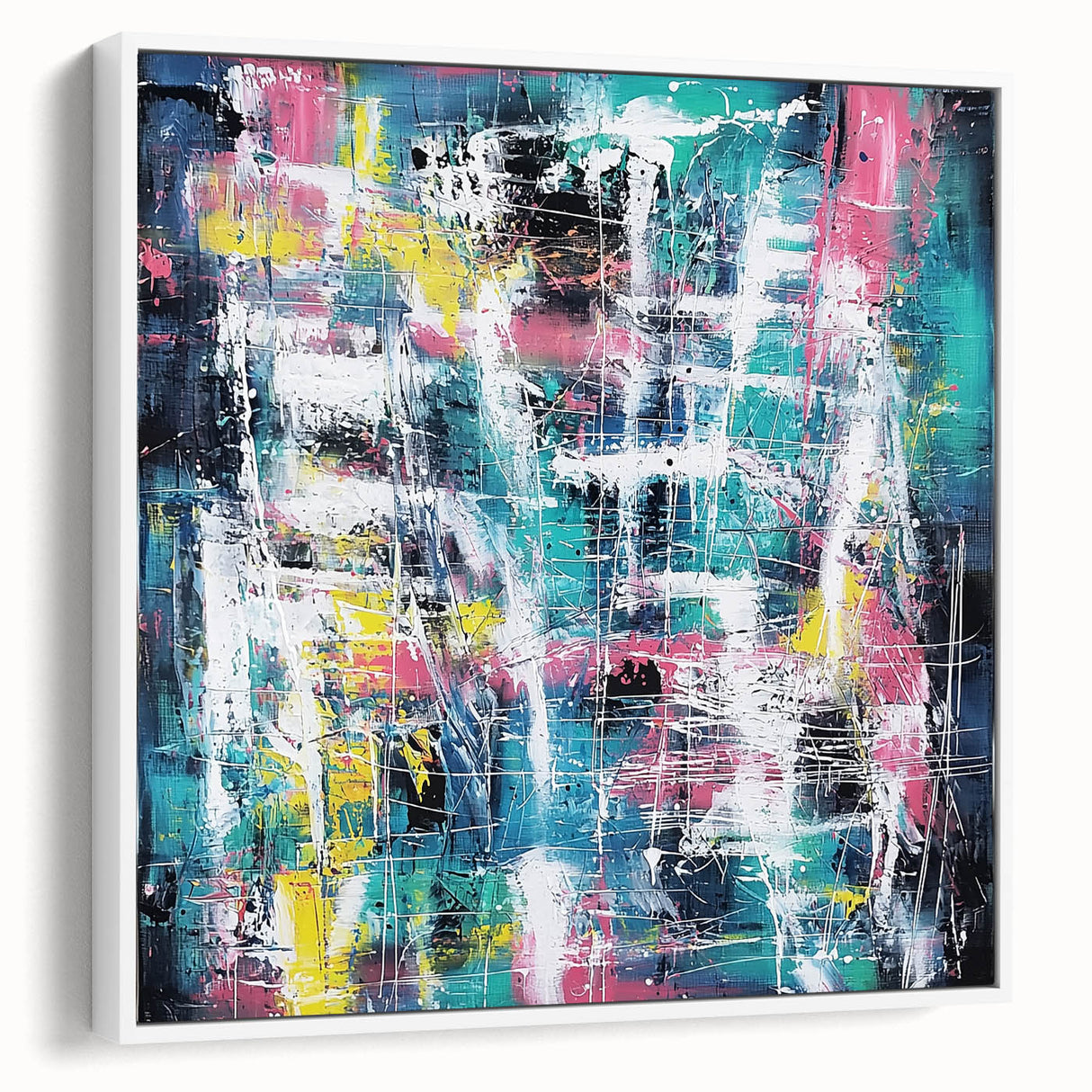Framed canvas artwork showcasing a modern abstract design with vibrant splatters in shades of blue, yellow, and red, set against a sleek white frame, ideal for contemporary decor.