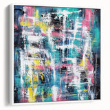Framed canvas artwork showcasing a modern abstract design with vibrant splatters in shades of blue, yellow, and red, set against a sleek white frame, ideal for contemporary decor.