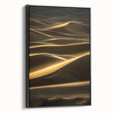 Framed canvas wall art showcasing a serene desert landscape with rolling dunes in warm beige and gold tones, featuring a sleek black frame, perfect for modern decor.