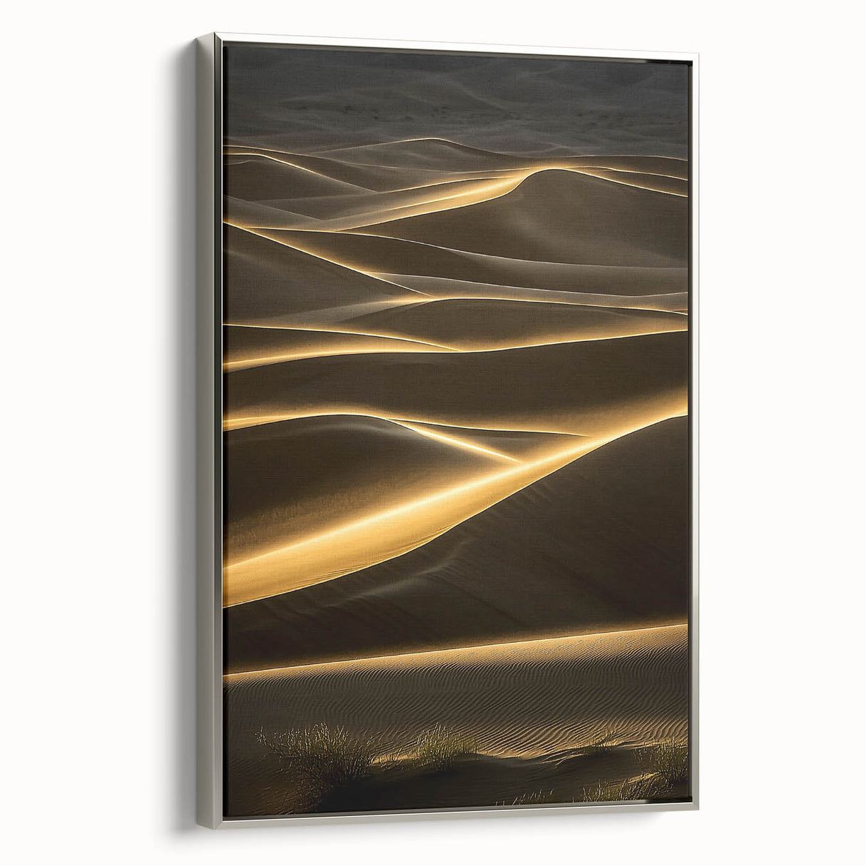 Framed canvas artwork showcasing serene desert dunes in soft beige and golden tones, elegantly displayed with a silver frame, ideal for modern home decor.
