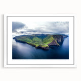 Framed landscape artwork depicting dramatic cliffs in a serene setting, featuring a white mat and sleek frame, perfect for enhancing home decor.