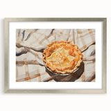 Textured art depicting assorted pastries in muted earth tones, framed in silver, suitable for kitchen or dining room decor.