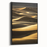 Framed canvas artwork showcasing a serene landscape of rolling sand dunes in warm tones, presented with a sleek black frame, perfect for modern décor.