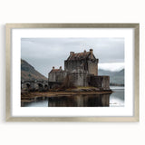 Framed landscape artwork depicting a majestic castle surrounded by lush greenery, featuring a silver mat and ornate frame, perfect for elegant home decor.