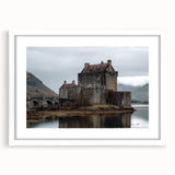 Framed landscape artwork showcasing a majestic castle surrounded by lush greenery, elegantly mounted with a white mat, perfect for home decor enhancement. Ideal for adding a touch of sophistication to any room's aesthetic.
