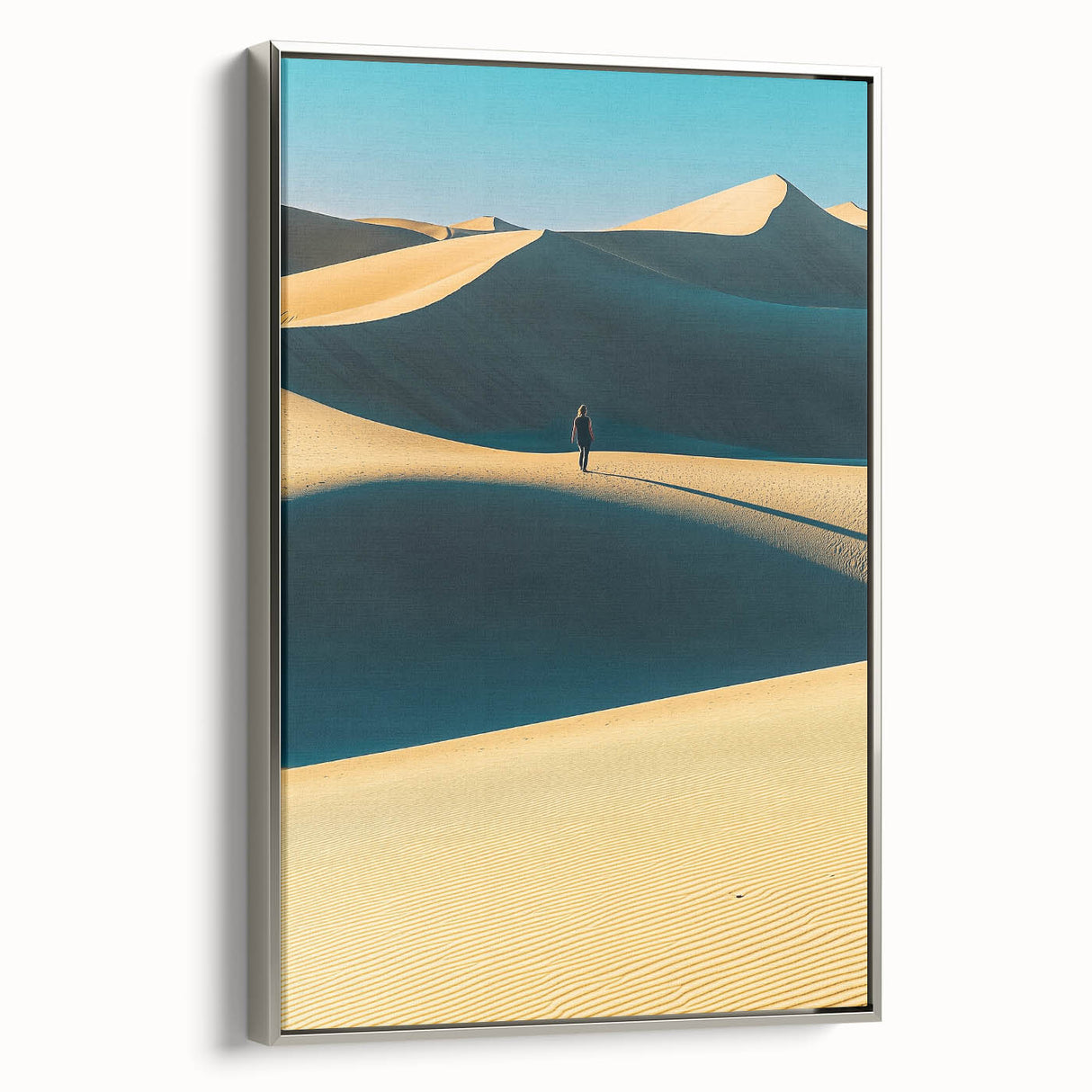 Framed canvas art depicting serene sand dunes in warm hues, showcasing a silver frame from the side, perfect for modern home decor and interior design aesthetics.