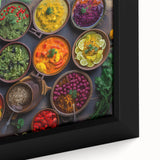 Close-up of a black framed canvas featuring an array of colorful, textured food dishes.